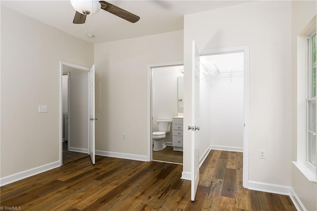 3820 Wayfarer Dr, Greensboro, NC 27410 - unfurnished bedroom featuring dark wood-type flooring, a walk in closet, ensuite bathroom, a closet, and baseboards