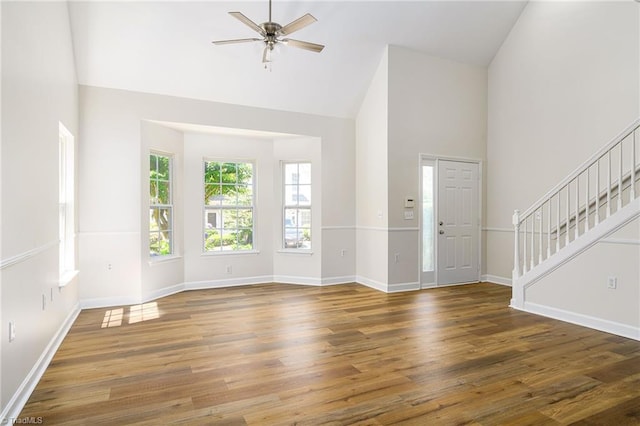 3820 Wayfarer Dr, Greensboro, NC 27410 - unfurnished living room featuring high vaulted ceiling, stairs, wood finished floors, a ceiling fan, and baseboards