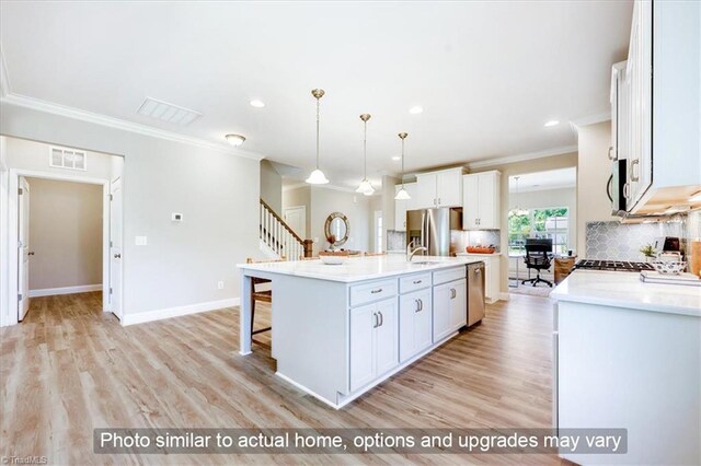 kitchen with crown molding, a kitchen breakfast bar, light wood finished floors, light countertops, and backsplash