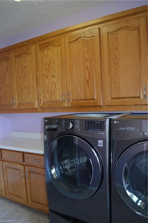 198 Savannah Ln, Mount Airy, NC 27030 - laundry area featuring cabinet space, washer and dryer, and light tile patterned floors