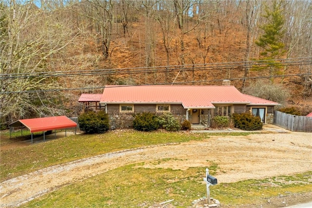 single story home featuring a front lawn, fence, and metal roof