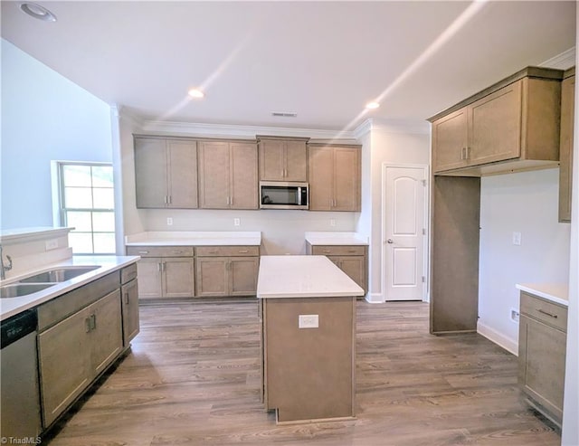 kitchen with hardwood / wood-style flooring, a kitchen island, appliances with stainless steel finishes, and sink