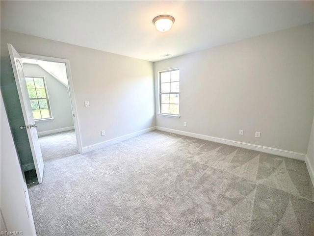 carpeted empty room with lofted ceiling