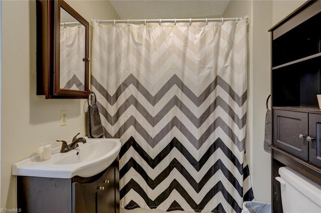 bathroom featuring a shower with curtain, vanity, and toilet