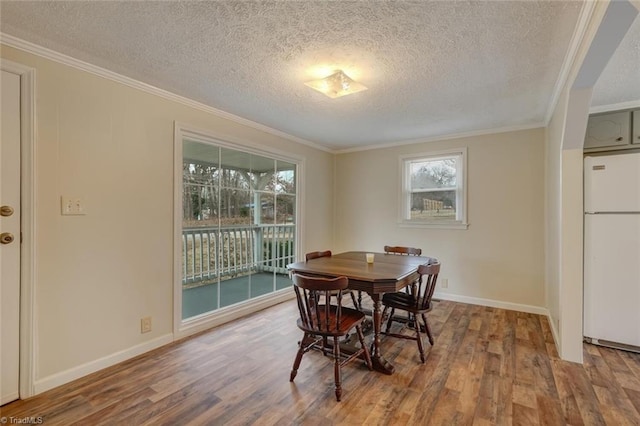 dining area with crown molding, a textured ceiling, and hardwood / wood-style flooring