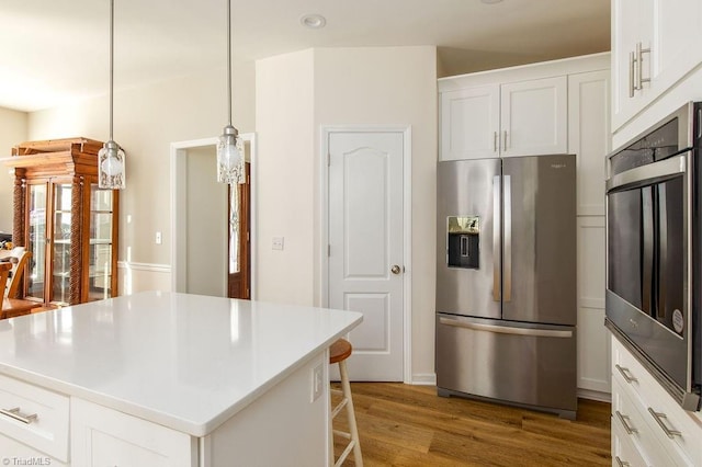 112 Havenwood Dr, Archdale, NC 27263 - kitchen featuring pendant lighting, a kitchen island, white cabinets, appliances with stainless steel finishes, and wood finished floors
