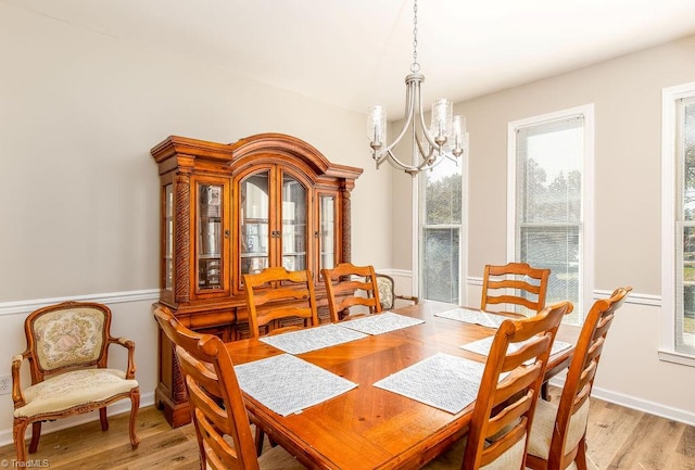 dining space featuring light hardwood / wood-style floors and a chandelier