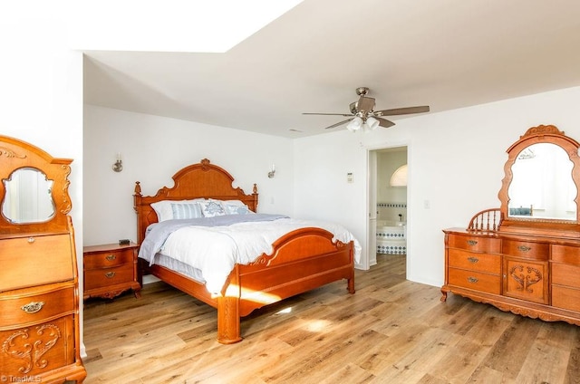 bedroom featuring ensuite bath, light hardwood / wood-style flooring, and ceiling fan