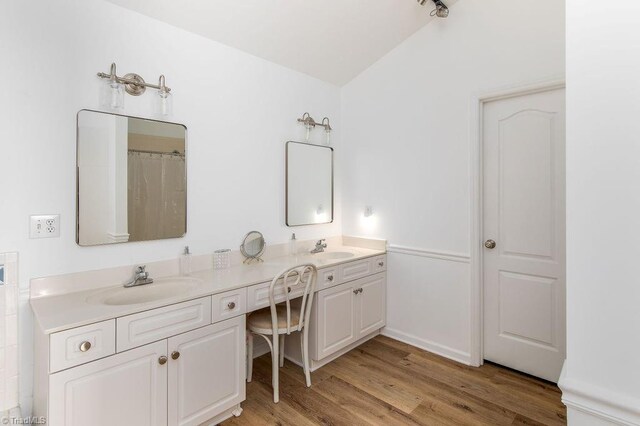 bathroom with vanity, lofted ceiling, and hardwood / wood-style flooring