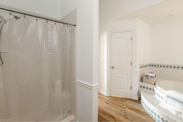 bathroom featuring plus walk in shower and wood-type flooring