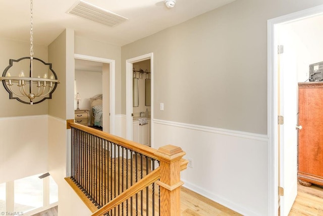 hallway featuring an inviting chandelier and light wood-type flooring