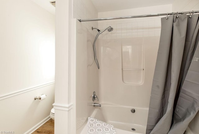 bathroom with toilet, wood-type flooring, and shower / bath combo with shower curtain