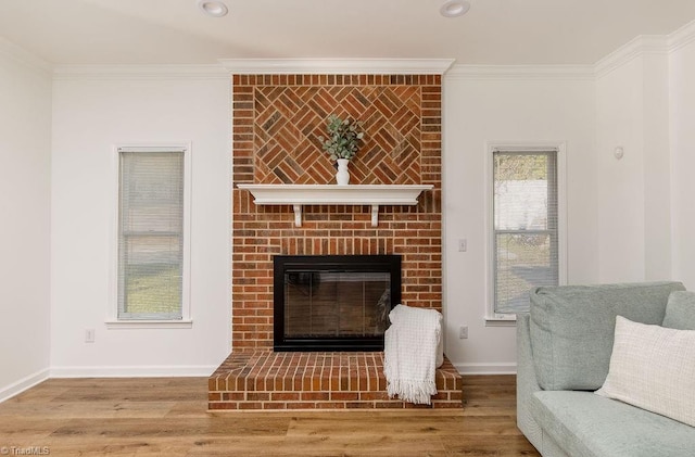 living room with ornamental molding, a brick fireplace, and hardwood / wood-style flooring