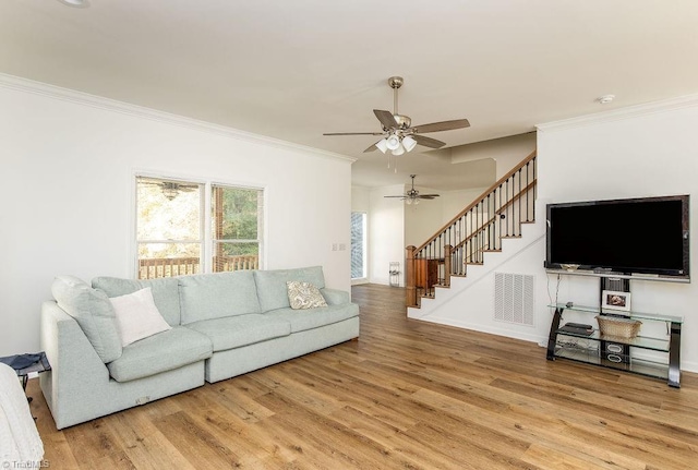 living room featuring hardwood / wood-style floors, crown molding, and ceiling fan