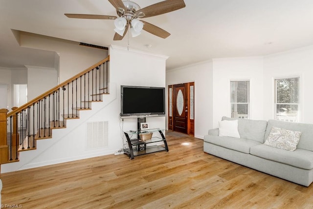 living room featuring ornamental molding, wood-type flooring, and ceiling fan