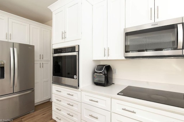 112 Havenwood Dr, Archdale, NC 27263 - kitchen with stainless steel appliances, white cabinetry, light countertops, and wood finished floors