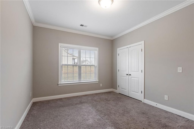 unfurnished bedroom featuring a closet, ornamental molding, and carpet flooring