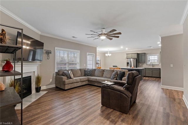 living room featuring a premium fireplace, crown molding, and dark hardwood / wood-style floors