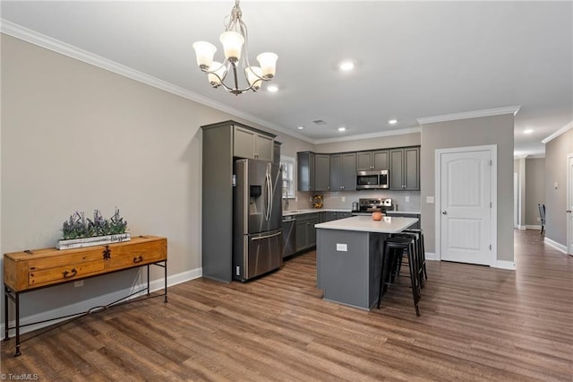 kitchen featuring appliances with stainless steel finishes, decorative light fixtures, a kitchen island, and gray cabinets