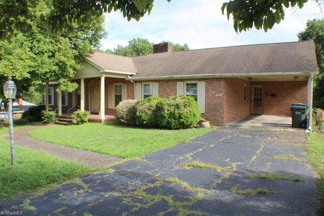 single story home featuring a carport, a front yard, and covered porch