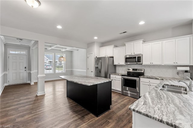 kitchen with a kitchen island, white cabinetry, appliances with stainless steel finishes, and sink