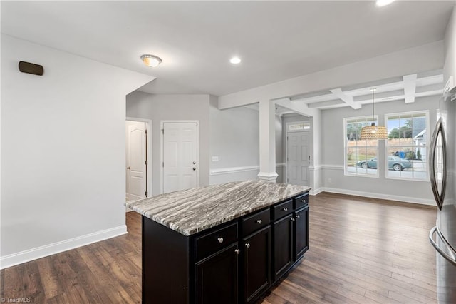 kitchen featuring hanging light fixtures, a center island, coffered ceiling, light stone countertops, and dark hardwood / wood-style flooring