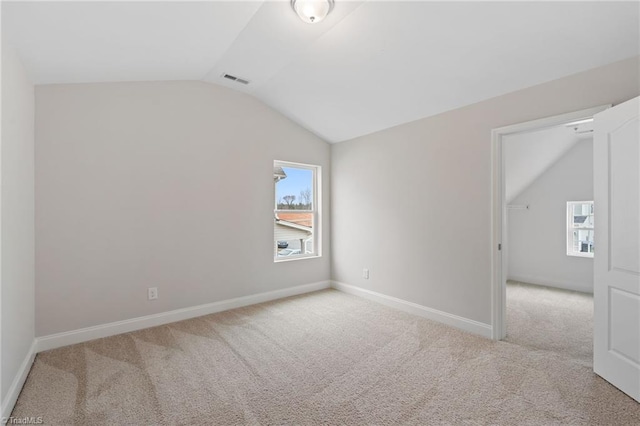 empty room featuring lofted ceiling and light carpet