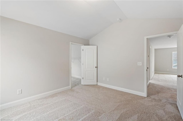 spare room with vaulted ceiling and light colored carpet