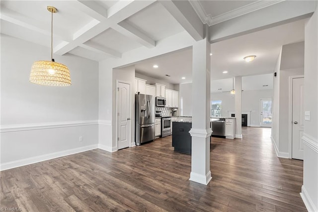 kitchen featuring appliances with stainless steel finishes, a center island, light stone countertops, white cabinets, and beamed ceiling