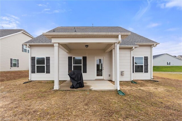 rear view of house featuring a yard and a patio area