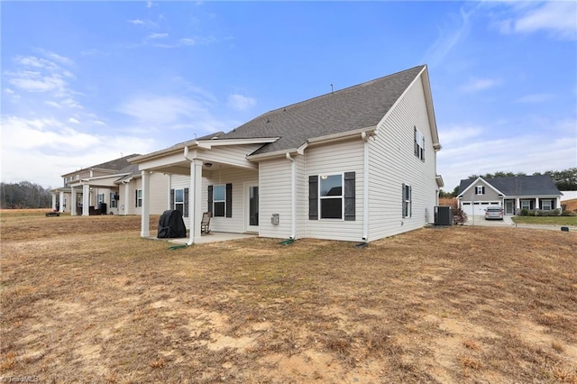 rear view of property featuring a lawn, a patio, and central air condition unit