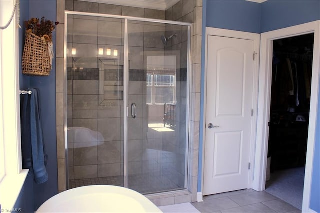 bathroom featuring a stall shower, tile patterned flooring, and a walk in closet