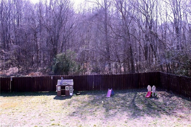 view of yard with a fenced backyard and a storage shed