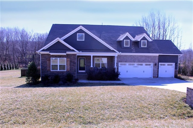 view of front of home with a garage, stone siding, a front lawn, and driveway