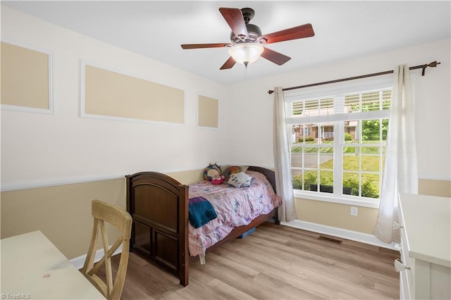 bedroom featuring baseboards, visible vents, ceiling fan, and light wood-type flooring