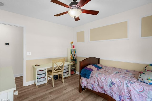 bedroom featuring baseboards, ceiling fan, and wood finished floors