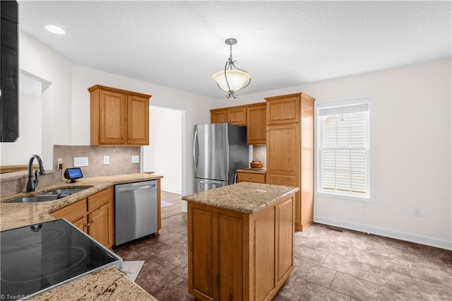 kitchen featuring a kitchen island, light stone countertops, tasteful backsplash, a sink, and stainless steel appliances