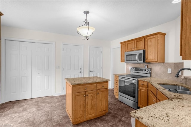 kitchen with a kitchen island, backsplash, a sink, light stone counters, and stainless steel appliances