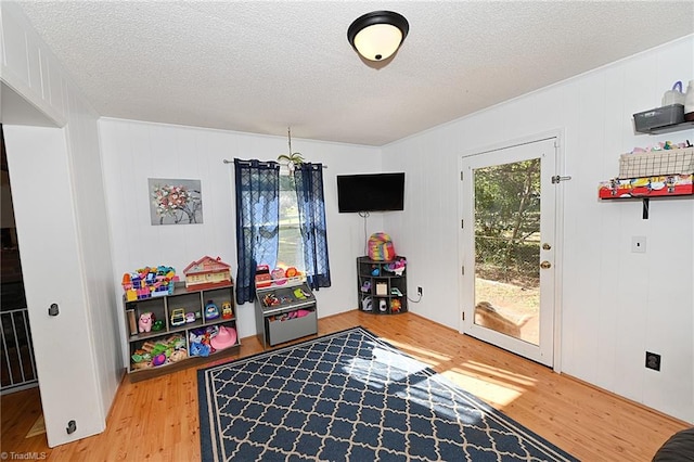 rec room with a textured ceiling and light wood-type flooring