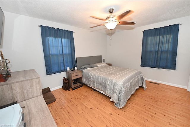 bedroom featuring hardwood / wood-style floors, a textured ceiling, and ceiling fan