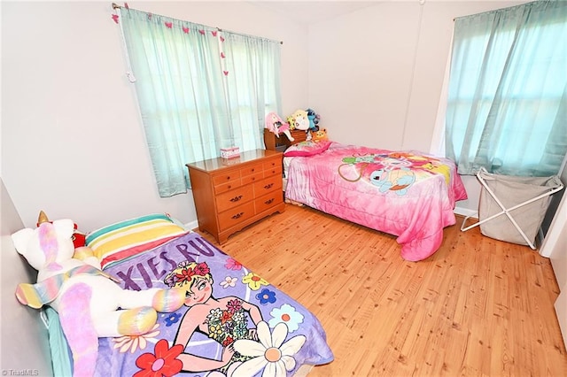 bedroom with multiple windows and wood-type flooring