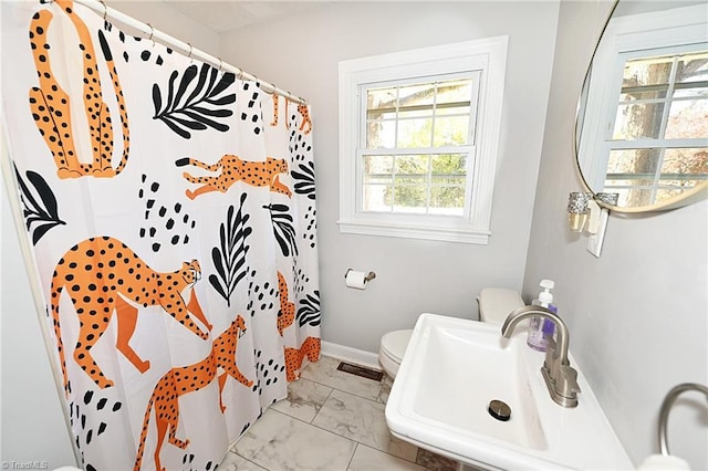 bathroom featuring sink, toilet, a wealth of natural light, and a shower with curtain