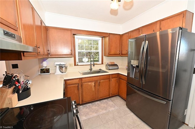 kitchen with range, sink, light tile patterned flooring, and stainless steel refrigerator with ice dispenser