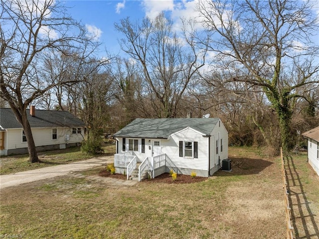 bungalow-style home featuring a front yard, crawl space, and dirt driveway