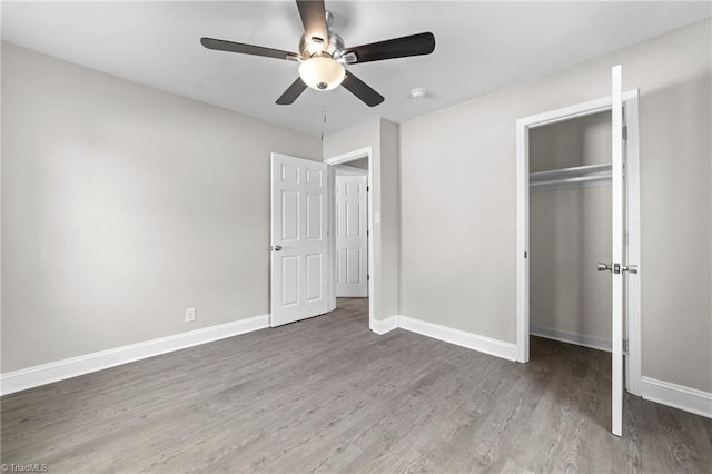 unfurnished bedroom with ceiling fan, a closet, wood finished floors, and baseboards