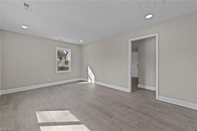 unfurnished room with visible vents, baseboards, wood finished floors, and recessed lighting