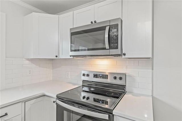 kitchen featuring backsplash, appliances with stainless steel finishes, crown molding, and white cabinetry