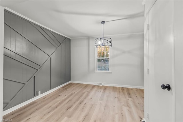 interior space with crown molding, a chandelier, and light hardwood / wood-style floors