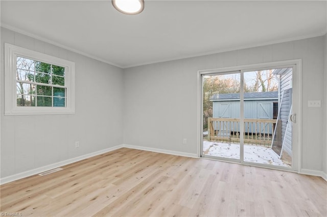 unfurnished room with crown molding, light hardwood / wood-style floors, and plenty of natural light