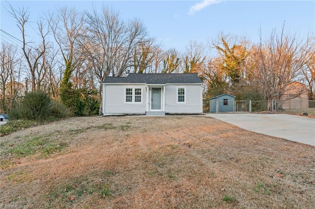 view of front of property featuring a front yard and a storage unit